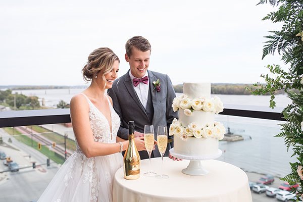couple cutting their wedding Cake overlooking the river