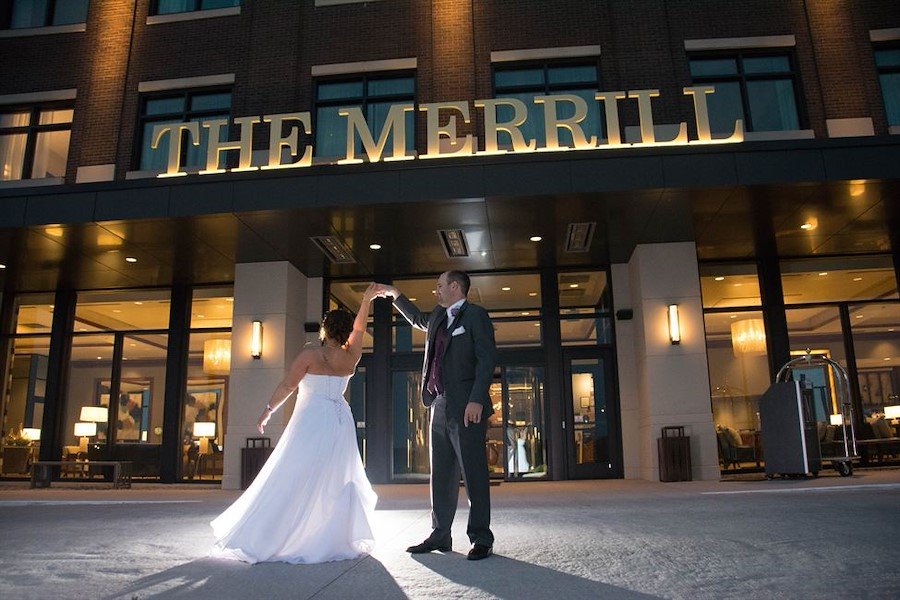 wedding couple standing in front of exterior of the Merrill Hotel