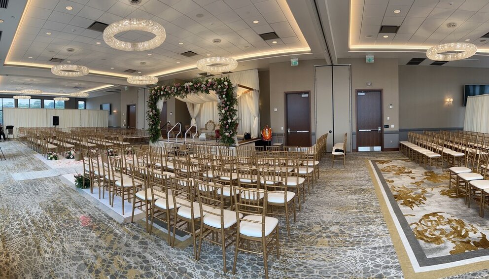 Wedding ceremony setup with chivari chairs and floral wedding arch