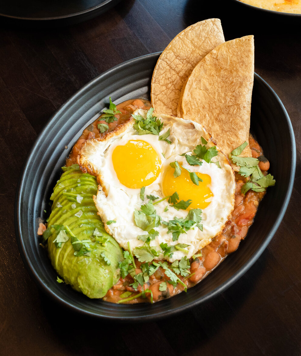 a bowl of food with eggs and tortillas