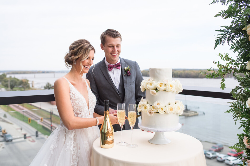 a man and woman standing next to a cake